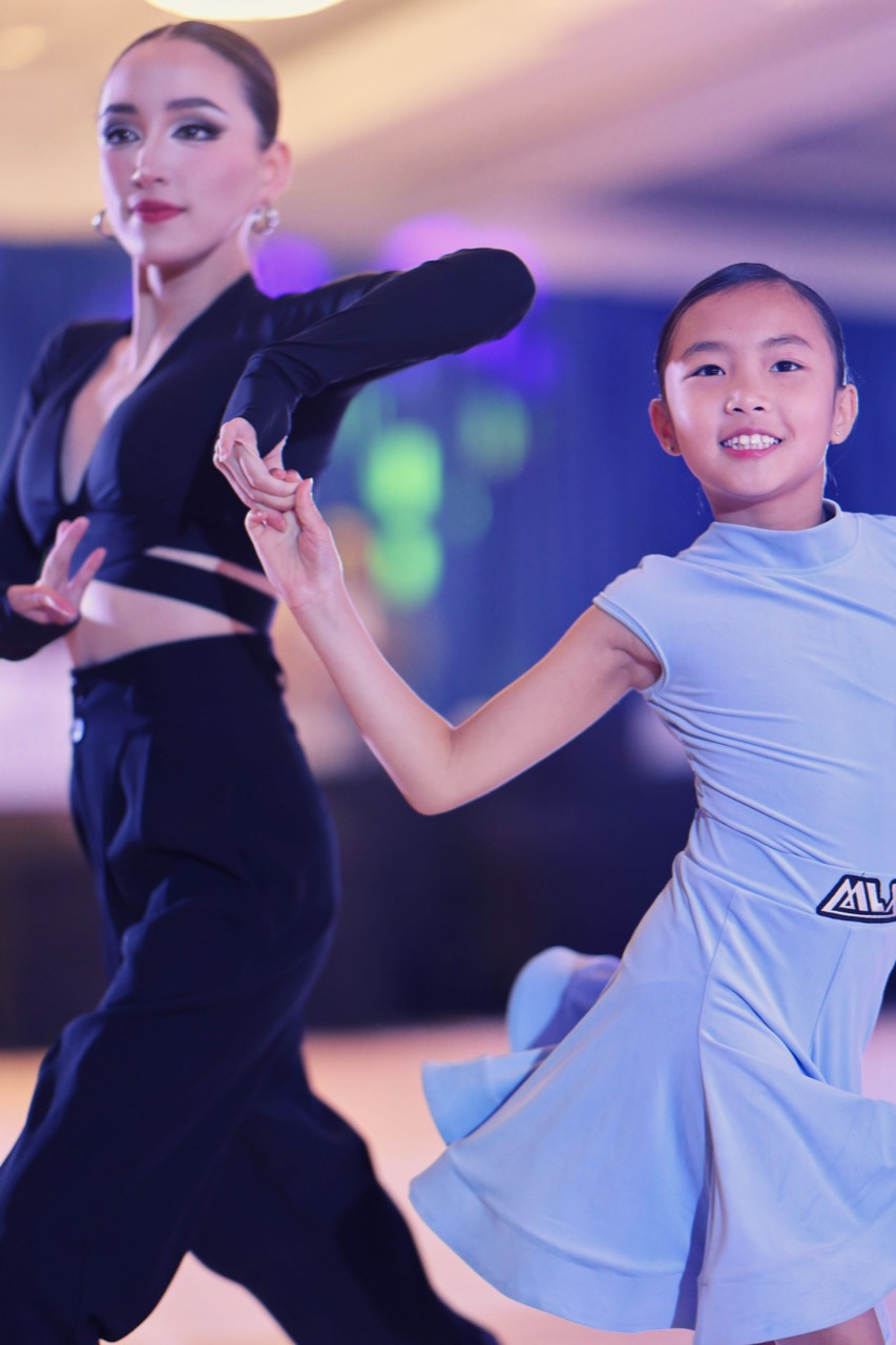Instructor dancing with a young Latin student